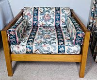 Front angled view of teak armchair with cushions