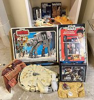 Group shot of boxed AT-AT, boxed Death Star playset, loose Millennium Falcon, Sandcrawler panel and accessories