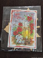 Front of sealed package showing God Jul artwork over wood maple leaf