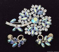 Front view of brooch and earrings showing aurora borealis stones and floral design