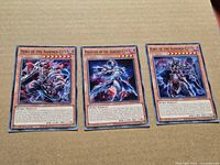 Group shot of three Ashened City cards on cardboard background