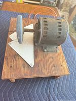 overall view of bench grinder on wooden base