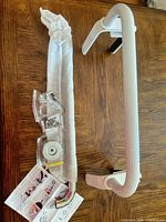 Two grab bars side by side with hardware and instruction sheet visible
