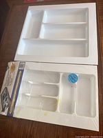 Two white plastic drawer organizers side by side, one wrapped, one unwrapped