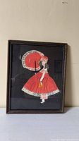 Full view of framed artwork showing lady with red dress