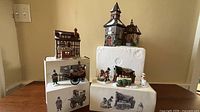 Overall lot showing two buildings and four figurine pieces