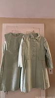 Front view of dress and coat hanging side by side