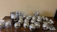 Wide view of assorted silver mirror disco balls in various sizes on table