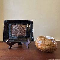 ceramic plate on stand beside gourd bowl