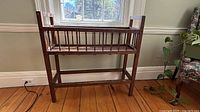 Front view of rectangular oak slatted plant stand showing overall structure and finish