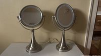 Front view showing both brushed nickel LED mirrors, cords visible
