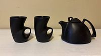 Front view of two mugs and teapot