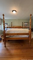 Full view of queen four-poster bed showing headboard, footboard, posts, finish, and size relation