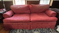 Front view of red damask three-seat sofa with cushions in place