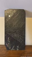 Front view of painted slate panel showing spider web, moon, thistle flowers, and keyhole hangers