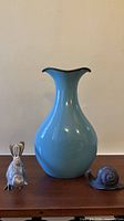 Overall view of ceramic vase flanked by bird and snail figurines