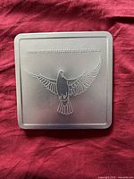 Closed metal tin with embossed dove and date text