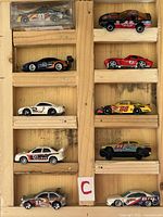 Front view of ten die-cast racing cars in wooden rack