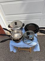 All cookware pieces assembled on stool in driveway