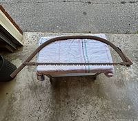 Full view of one-man crosscut saw on bench showing arched frame and blade