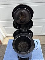 Coffee maker open showing brew basket and interior components