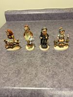 All four Hummel figurines grouped on countertop