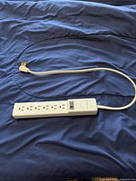 6-outlet power strip with short cord displayed on bed