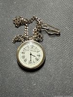 Front view showing Telus dial, Roman numerals, chain and clasp