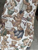 Full view of multicolor teddy bear tapestry throw blanket draped to show pattern and texture