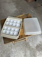 Tupperware deviled egg transporter open showing two white trays and detached lid