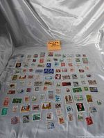Full layout of 100 Canadian stamps on fabric background
