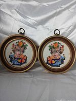 Both framed cross-stitch portraits side by side