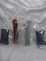 Five fabric catnip toys in plastic bags, front view