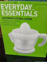 Retail box showing Everyday Essentials Automatic Citrus Juicer branding and product image