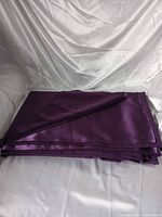 Folded purple fabric on white backdrop