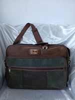 Front view of Jaguar travel bag showing size, colors, handle and front pocket