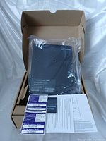 Box opened showing Telus T3200M modem sealed in plastic with paperwork