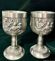 Front view of both pewter goblets showing embossed figures