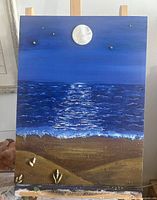 Full view of mixed-media seascape painting on easel