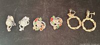 All three pairs of earrings aligned: opalescent cabochon pair, rhinestone wreath pair, gold braided hoop pair