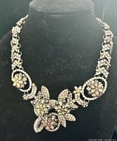 Front view of silver-tone Zara necklace on bust showing floral rhinestone design