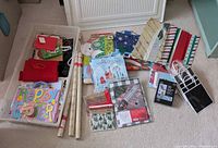 Entire lot laid out showing tote, bags, boxes, wrapping paper rolls, books, plush bunny, cards.