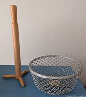 wire mesh basket and wooden paper towel holder side by side