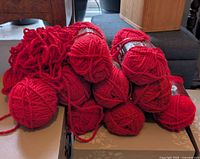 Stack of red yarn skeins, one unwrapped