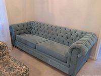 Front view of blue tufted sofa showing overall design and condition