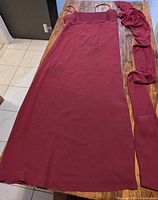 Full view of burgundy dress and shawl laid flat