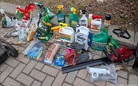 Group shot of gardening supplies, chemicals, bags of soil, tools, gloves, netting, wheel and hedge trimmer