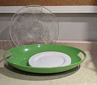 Group shot showing clear platter, green tray, white plate for scale