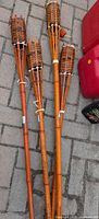 Four bamboo tiki torches laid on paving stones