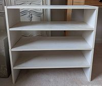 Front view of stacked white two-shelf shoe racks